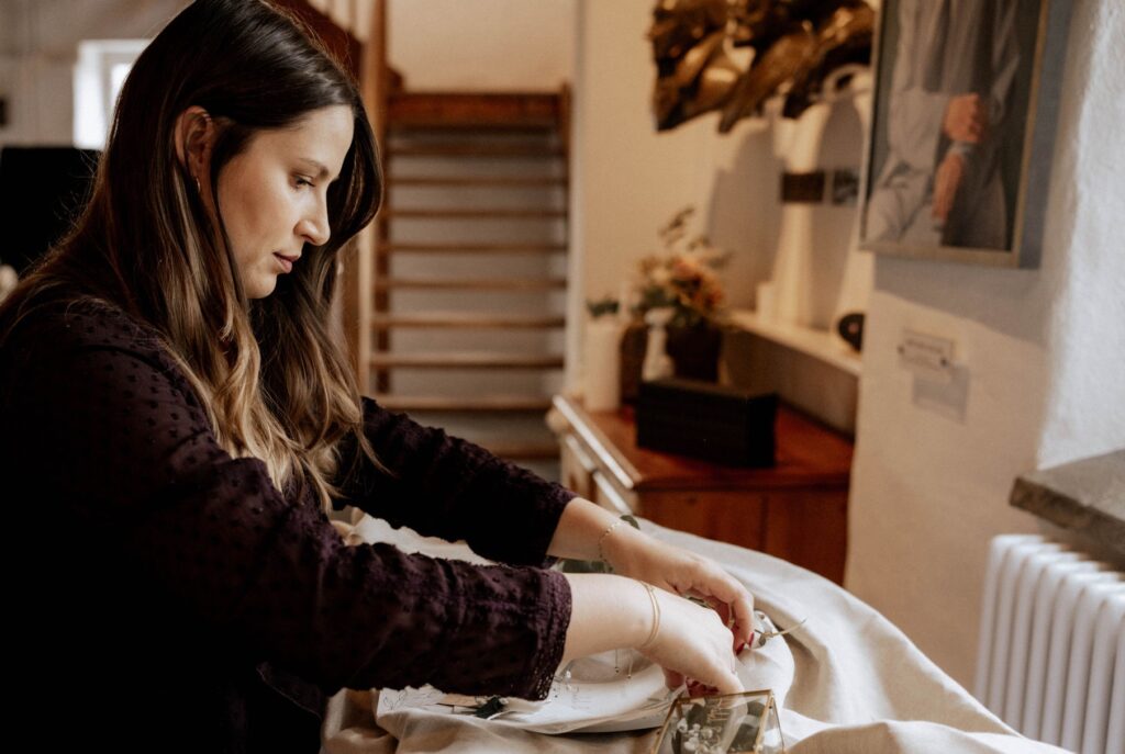 Francine , Designerin für Hochzeitspapeterie, beim Arrangieren eines Flatlays für eine Fotografin